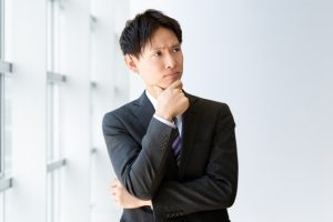 考えるスーツ姿の男性