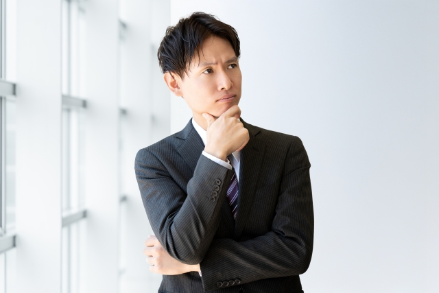 考えるスーツ姿の男性